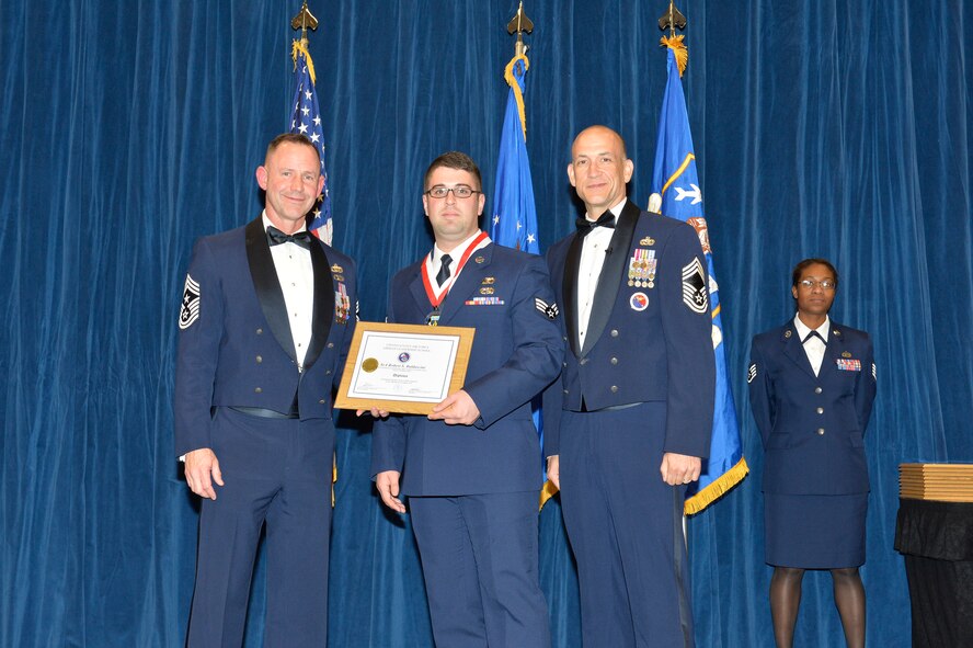 Senior Airman Robert Baldascini receives the Distinguished Graduate Award for Airman leadership school class 17-1 from Chief Master Sgt. David Eddy, Chief Master Sgt. of the Michigan Air National Guard, and Chief Master Sgt. Edward Walden, Sr., Commandant of the Paul H. Lankford Enlisted PME Center, here, Nov. 15, 2016, at the I. G. Brown Training and Education Center. The distinguished graduate award is presented to students in the top 10 percent of the class. (U.S. Air National Guard photo by Master Sgt. Jerry D. Harlan/Released)