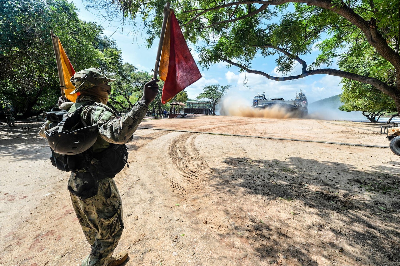 Navy Petty Officer 3rd Class Andre' Brown, assigned to the amphibious transport dock ship USS Somerset, directs an air cushioned landing craft onto the beach during a theater security cooperation engagement exercise with the Sri Lankan military in Sri Lanka, Nov. 23, 2016. The Somerset and the 11th Marine Expeditionary Unit are conducting the exercises with Sri Lankan forces to enhance tactical skill sets and disaster relief capabilities while strengthening the overall relationship between the two forces. Navy photo by Petty Officer 3rd Class Amanda Chavez