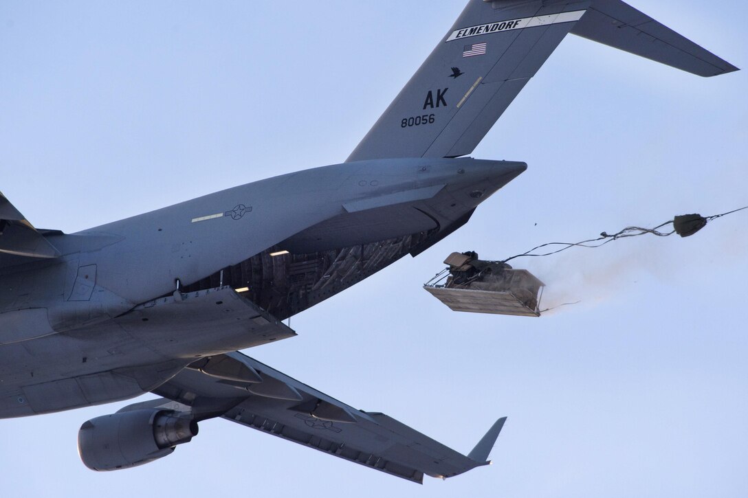 An Air Force C-17 Globemaster III drops a heavy equipment pallet over Malemute drop zone, Joint Base Elmendorf-Richardson, Alaska, Nov. 22, 2016. Air Force photo by Alejandro Pena