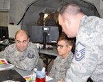 Massachusetts Air National Guard weather forecaster assigned to the 202nd Weather Flight, Cape Cod discuss weather conditions during a Warfighter command post exercise on Nov. 10, 2016, at Fort Indiantown Gap, Pa. 