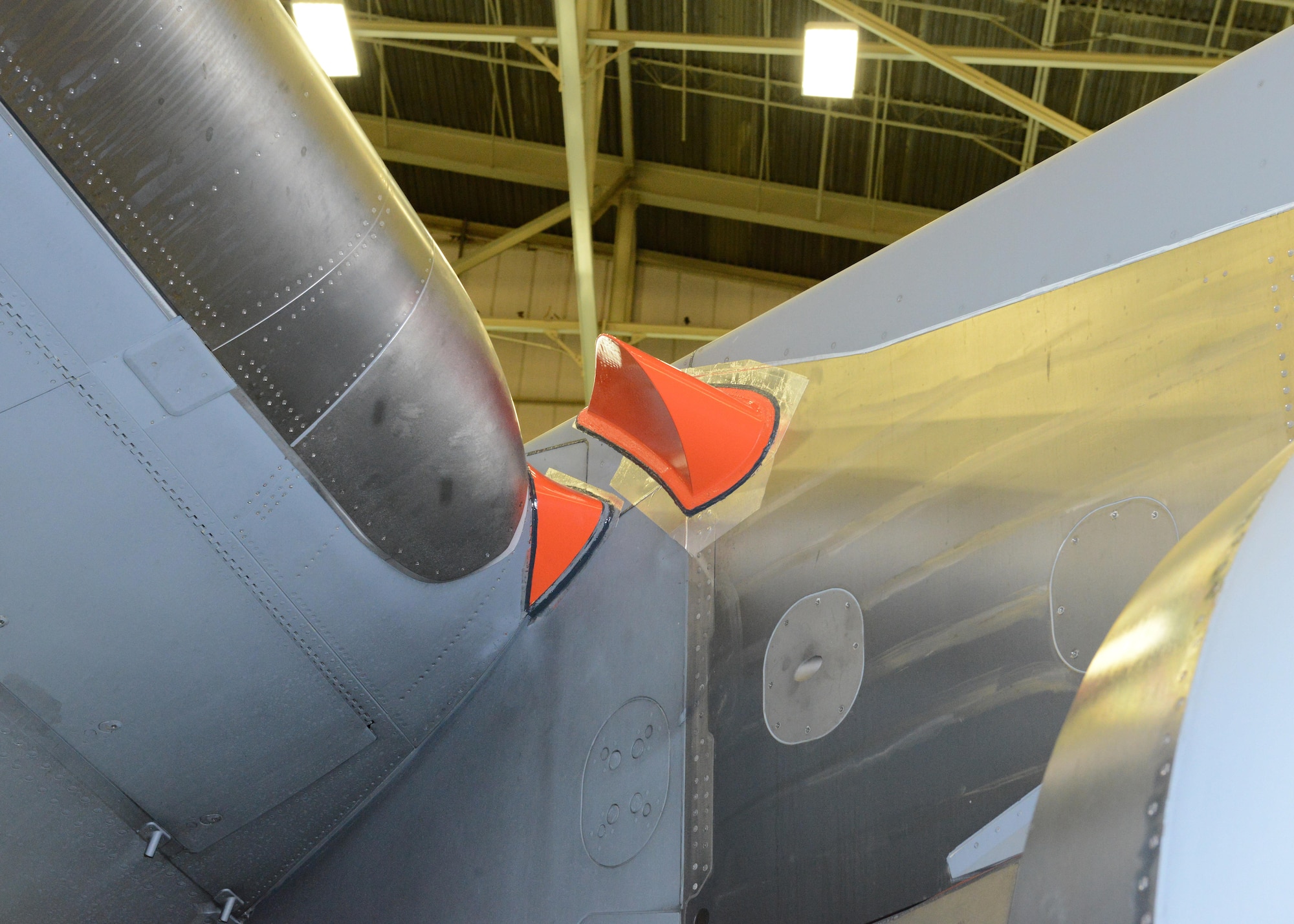 Three fairings are placed near the leading edge of the wing at the engine pylons of a C-17 for phase four of C-17 Drag Reduction testing. The fairings are placed in areas where indications of airflow disturbance were identified during computer simulations. Phase four tested the fairings along with six microvanes on each side of the aft fuselage of the aircraft. (U.S. Air Force photo by Kenji Thuloweit)