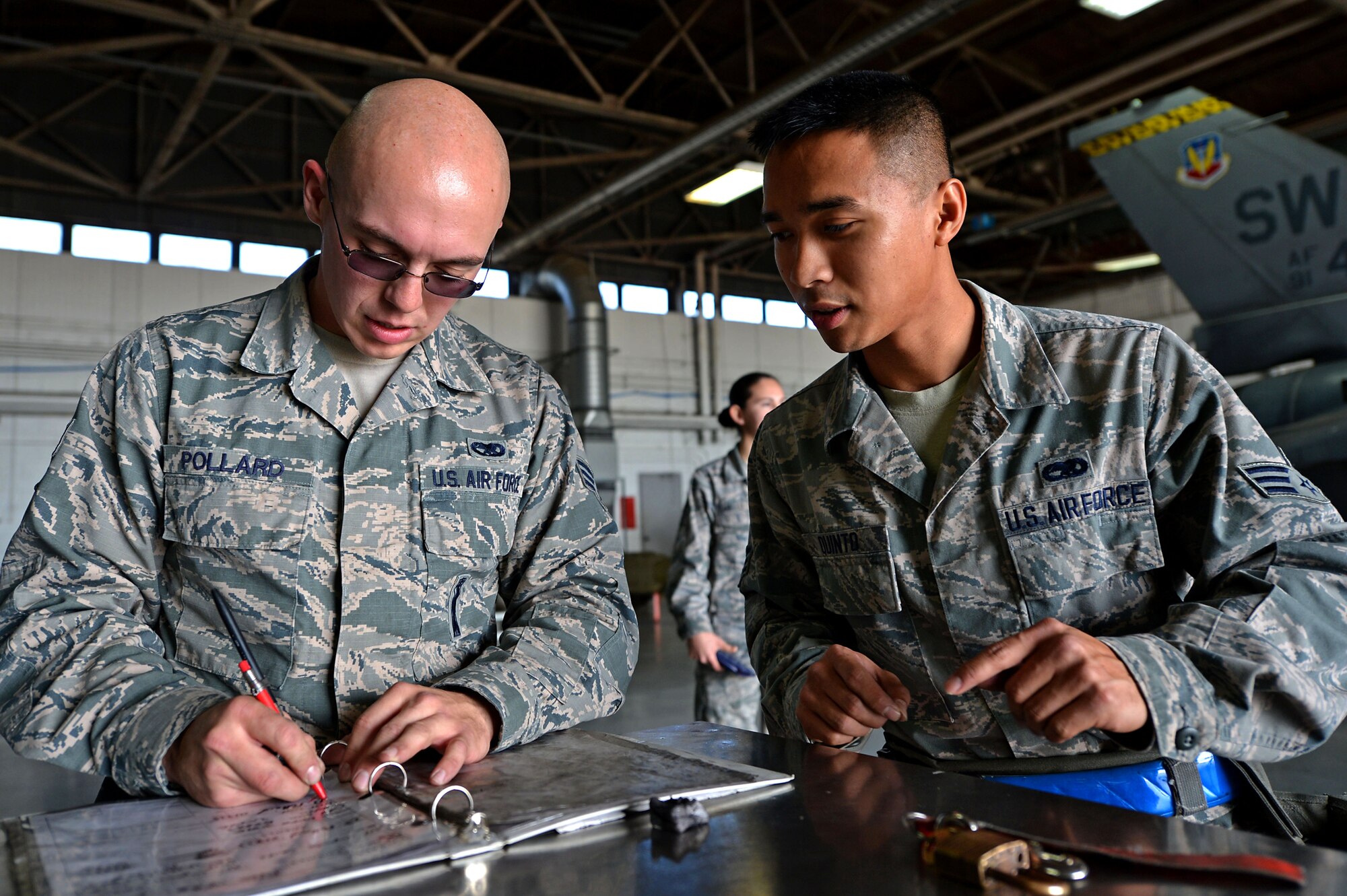 U.S. Air Force Senior Airman Benjamin Pollard, 20th Aircraft Maintenance Squadron load crew member, left, and Senior Airman James Quinto, 20th AMXS load crew member, right, fill out an after-action report during a Load Crew of the Quarter competition at Shaw Air Force Base, S.C., Nov. 23, 2016. Evaluators assessed the safety, accuracy and speed of the three-person teams as they loaded the munitions. (U.S. Air Force photo by Airman 1st Class Christopher Maldonado)