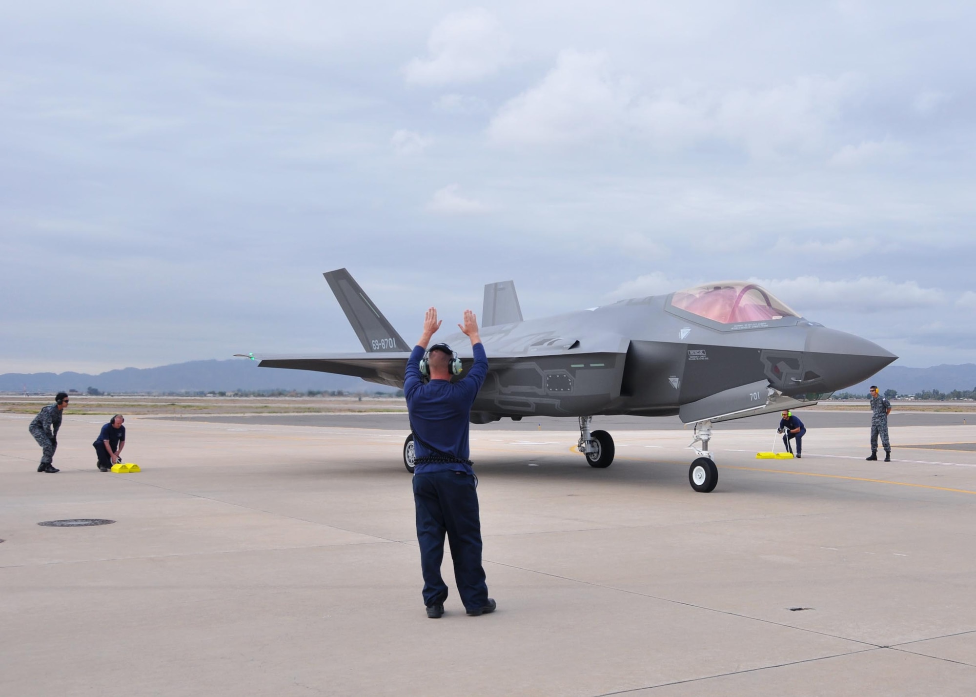 Lockheed Martin and Japanese Air Self-Defense Force personnel work together to taxi in the arrival of the first Foreign Military Sales F-35A onto the 944th Fighter Wing ramp Nov. 28 at Luke Air Force Base, Ariz. The arrival marked the next step for the international F-35 training program. (U.S. Air Force photo by Tech. Sgt. Louis Vega Jr.)
