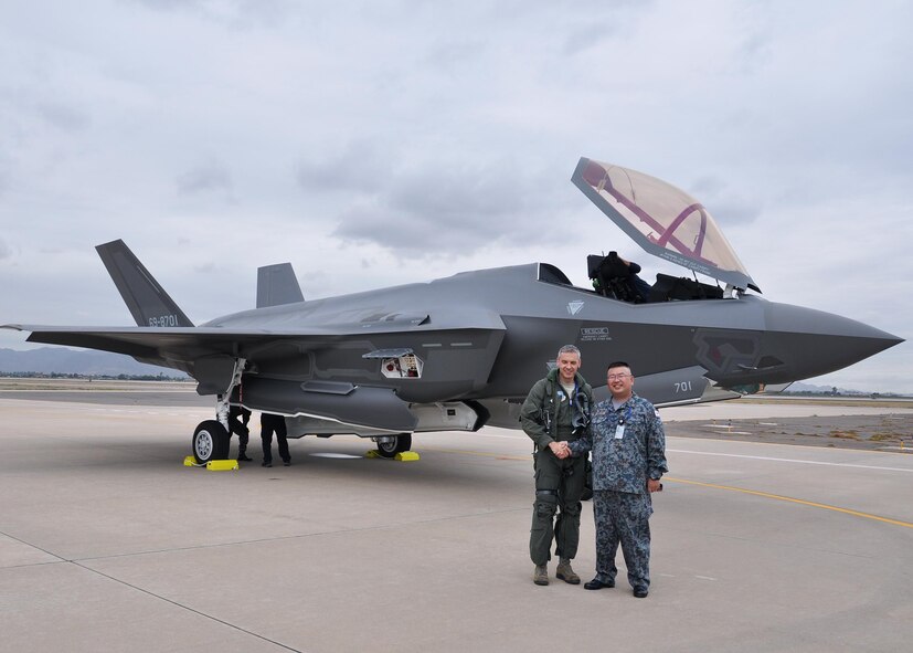A foreign liaison officer from the Japan Air Self-Defense Force and U.S. Air Force Lt. Col. Todd Lafortune, Defense Contract Management Agency Lockheed Martin, F-35 acceptance pilot, shake hands Nov. 28, 2016 during the arrival of the first Foreign Military Sales F-35 at Luke Air Force Base, Ariz. (U.S. Air Force photo by Tech. Sgt. Louis Vega Jr.)