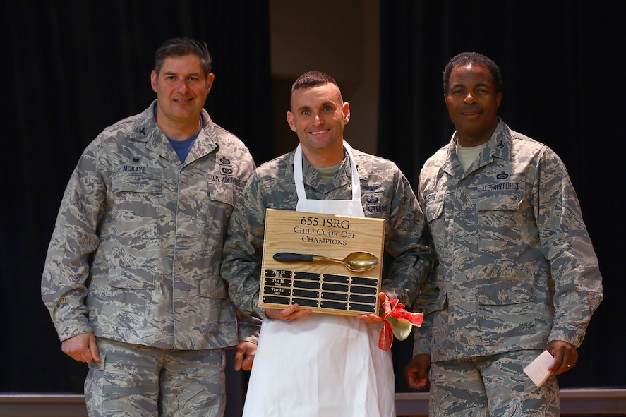 Capt. James Spindler, 64th Intelligence Squadron, is the winner of the 2016 655th Intelligence, Surveillance and Reconnaissance Group Chili Cook-Off at the USO here Nov. 19, 2016. The captain received his apron award from Col. John D. McKaye, 655th ISRG commander (left) and Col. Lonnie Garris, III, 655th ISRG deputy commander. Capt. Spindler’s chili won in the ‘Best Overall’ category. The other three categories judged were: spiciest, white chili and most creative. (U.S. Air Force photo /Tech. Sgt. Patrick O’Reilly)