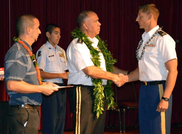 Capt. Ramee Opperude, assigned to Headquarters and Headquarters Company, 3rd Brigade Combat Team, 25th Infantry Division, is handed a coin by Lt. Gen. Anthony Crutchfield, deputy commander, U.S. Pacific Command, during the 15th Annual Joint Venture Education Forum (JVEF) at the Hawaii Convention Center, Honolulu, Nov. 28, 2016.  Opperude was recognized for his volunteerism at several Hawaiian schools this year. (U.S. Army photo by Staff Sgt. Armando R. Limon, 3rd Brigade Combat Team, 25th Infantry Division)st