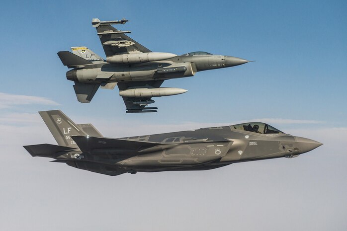 In this file photos, an F-35A Lightning II flies alongside an F-16 Fighting Falcon June 25, 2015, at Luke Air Force Base, Ariz. In October, F-35 and F-16 pilots began integrated training designed to improve mission cooperation and flight skills in both airframes. 