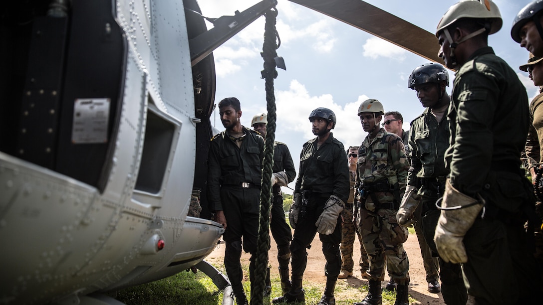 TRINCOMALEE, Sri Lanka (Nov. 23, 2016) Sri Lankan Navy Special Boat Squadron Sailors are instructed how to safely maneuver through the UH-1Y Huey helicopter during a Theater Security Cooperation engagement at Sri Lanka Naval Base, Trincomalee, Nov. 23, 2016. A majority of the SBS Sailors has never conducted fast rope techniques from an actual helicopter, so understanding the safety procedures and familiarizing themselves with the Huey prior to loading the aircraft was critical to the training event and everyone's safety. This bilateral training provides an opportunity for Sri
Lanka and U.S. Navy and Marine Corps teams to further enhance military ties and improve their capability and proficiency to respond to crises. (U.S. Marine Corps photo by Gunnery Sgt. Robert B. Brown/Released)
