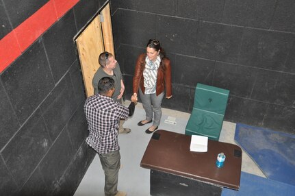 Jennifer Schuett, vice consul, Consulate General Ciudad Juarez, Mexico, right, shakes the hand of Sgt. Cesar Medina, assigned to Company B, 410th Civil Affairs Battalion, U.S. Army Reserve, during close-quarters combat training at McGregor Range, N.M., Nov. 19. Sgt. Ryan Hernandez, center, also assigned to Co. B, 410th CA Bn., looks on. Schuett, observing the training for the U.S. State Department, posed as a mayor during the training.