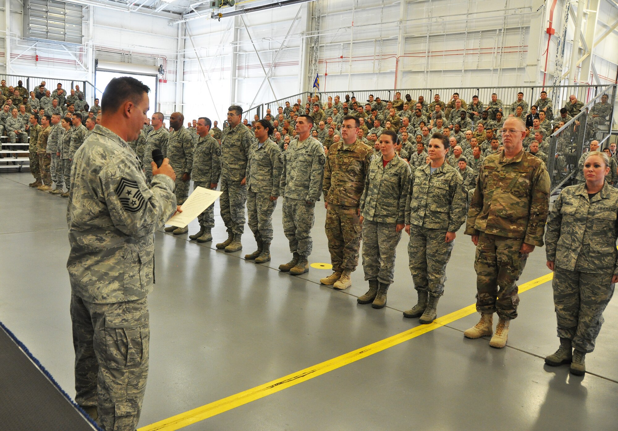 Dozens of recently promoted 919th Special Operations Wing master sergeants stand at attention as Chief Master Sgt. Brian Bischoff, the wing's command chief, reads the Senior NCO Charge during their induction ceremony at Duke Field, Fla., Nov. 6, 2016.  The event, which inducts Airmen into the top tier of the enlisted force, capped off the three-day November unit training assembly's commander's call. (U.S. Air Force photo/Dan Neely)   