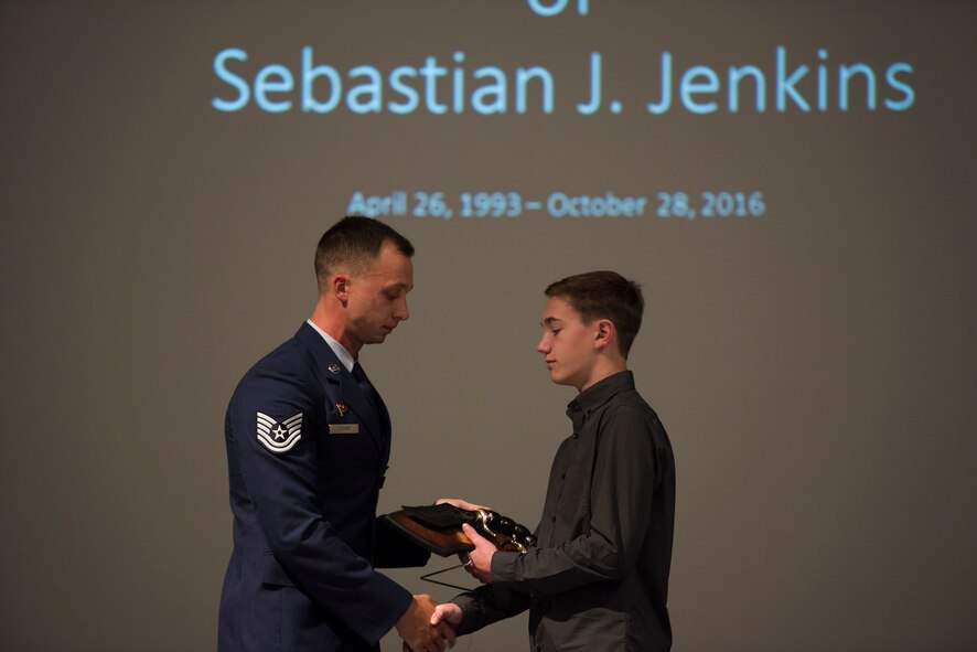 In honor of the late Senior Airman Sebastian Jenkins, 822d Base Defense Squadron fire team member, Tech. Sgt. Wayne LeVan, 822d BDS NCO in charge of training, gives a scorpion knife to Jenkins’ brother, Tristan, during a memorial service, Nov. 29, 2016, at Moody Air Force Base, Ga. LeVan said that although Tristan lost a brother, he will always be a part of the 822d BDS’s brotherhood by accepting the knife in Sebastian’s honor. (U.S. Air Force photo by Airman 1st Class Greg Nash) 
