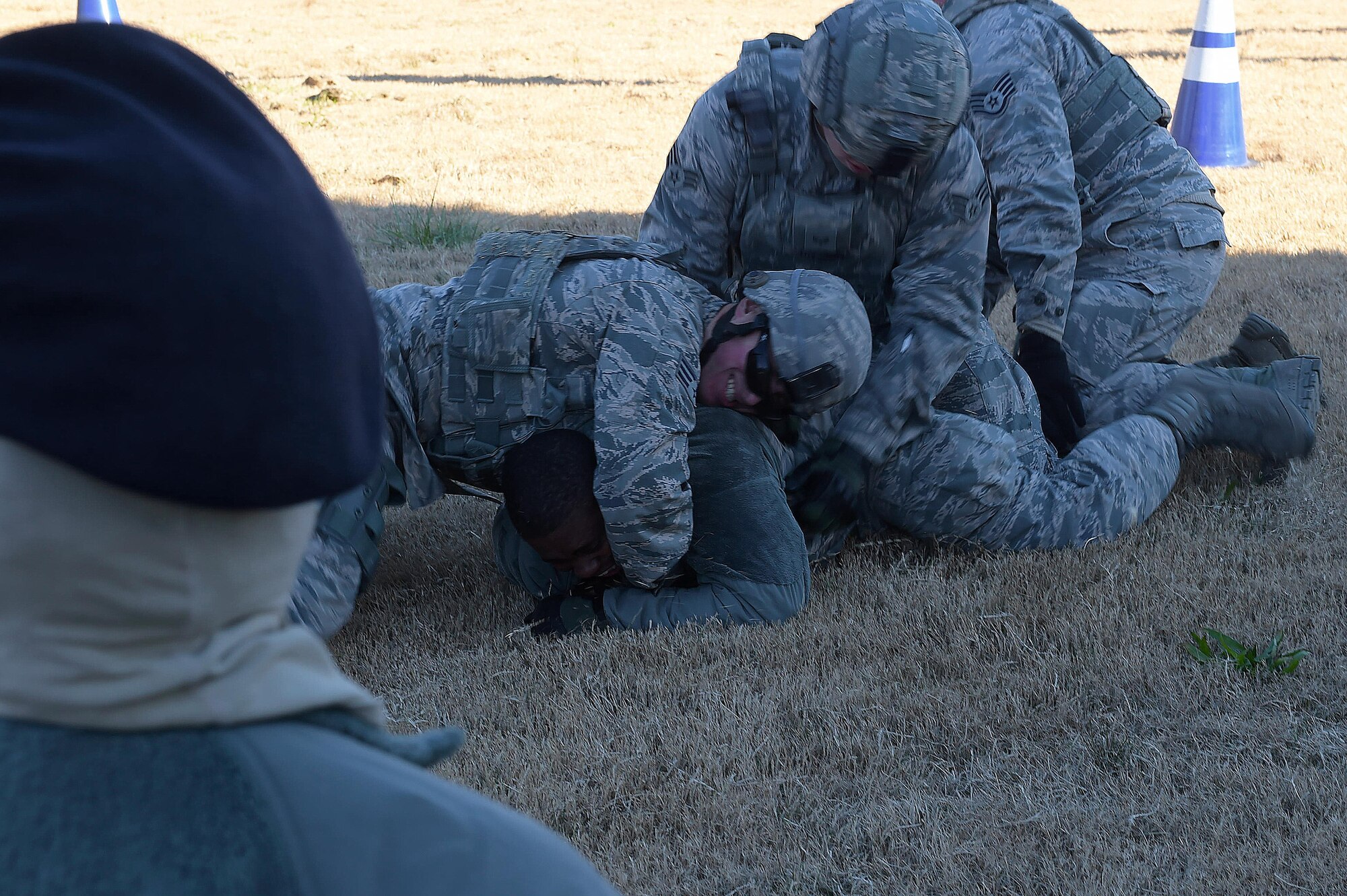 A member of the 633rd Security Forces Squadron observes fellow defenders apprehending an individual as part of a training at Joint Base Langley-Eustis, Va., Nov. 21, 2016. The training focused on protocols involved with protecting an F-22 Raptor on display. (U.S. Air Force photo by Senior Airman Kimberly Nagle)
