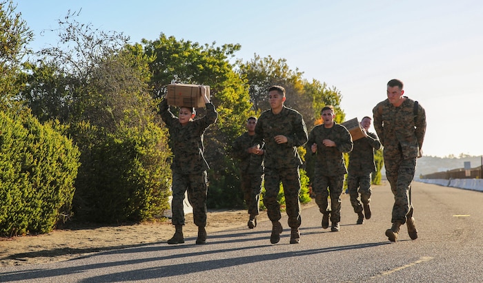 Marines of Headquarters and Service Battalion conduct a three-mile run during the Atlas Games at Marine Corps Recruit Depot San Diego, Nov. 22. The Marines were required to carry water jugs, ammunition cans and boxes of Meals Ready to Eat during the run. The Atlas Games consisted of pull-ups, a three-mile run, tire flips, a simulated medical evacuation and a tug-of-war competition at the end of the games. Various units of the battalion competed for a 72-hour liberty period.