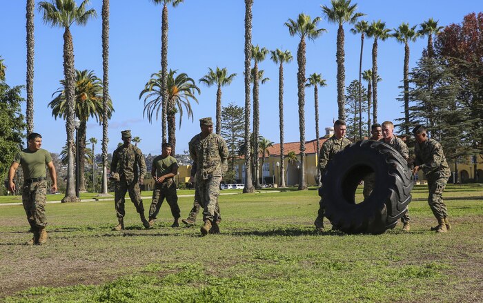 Marines of Headquarters and Service Battalion flip a tire for 40 yards as a timed event during the Atlas Games at Marine Corps Recruit Depot San Diego, Nov. 22. The Atlas games consisted of pull-ups, a three-mile run, tire flips, a simulated medical evacuation and a tug-of-war competition at the end of the games. Various units of the battalion competed for a 72-hour liberty period.