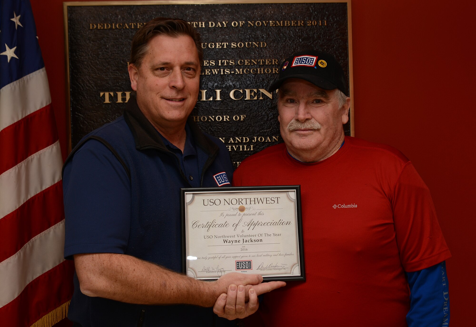 Don Linegang, USO Northwest executive director, presents Wayne Jackson, USO Northwest Shali Center volunteer the USO Northwest Volunteer of the Year Award for his volunteer work at the Shali Center. Jackson was also awarded a gold Presidential Volunteer Service Award for volunteering more than 500 hours this year. (U.S. Air Force photo/Senior Airman Jacob Jimenez)  
