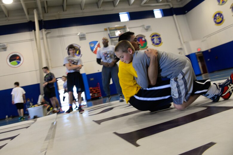 SCHRIEVER AIR FORCE BASE, Colo.-- 2nd Lt. Marco Lara, World Class Athlete Program wrestler, grapples with Jaxton Sola during a wrestling demonstration at the fitness center at Schriever Air Force Base, Colorado, Nov. 15, 2016. The demonstration was an opportunity for wrestlers and potential wrestlers to try and learn the sport learning from top tier athletes. (U.S. Air Force photo/Christopher DeWitt)