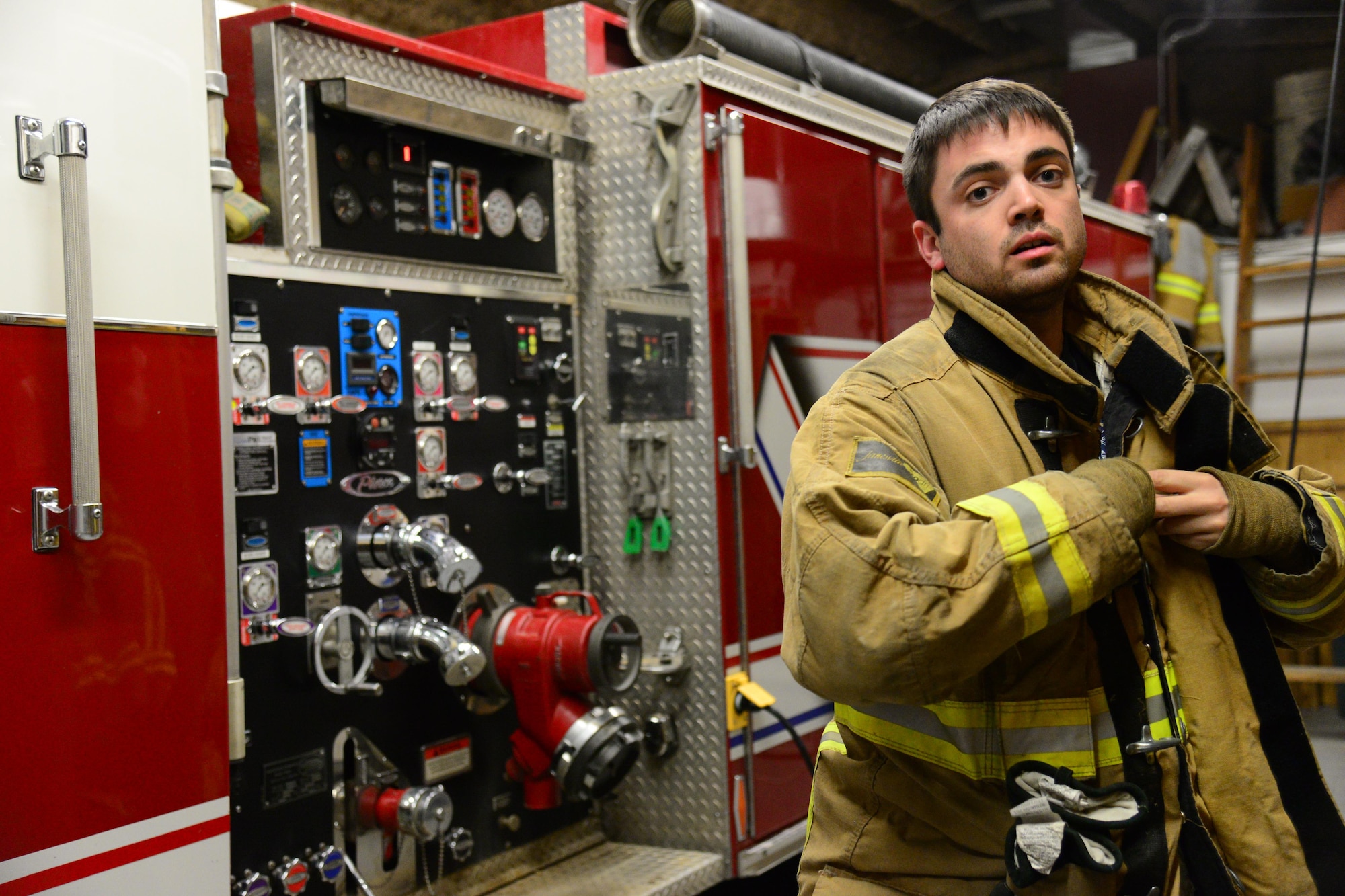 1st Lt. Anthony Perkins, 490th Missile Squadron intercontinental ballistic missile combat crew commander, puts on the gear he wears as a volunteer firefighter Nov. 8, 2016, at Great Falls Gore Hill Volunteer Fire Department, Great Falls, Mont. Perkins spends the majority of his off-duty time as a volunteer firefighter and as an ambulance emergency medical technician for Great Falls Emergency Services. (U.S. Air Force photo/Airman 1st Class Magen M. Reeves)