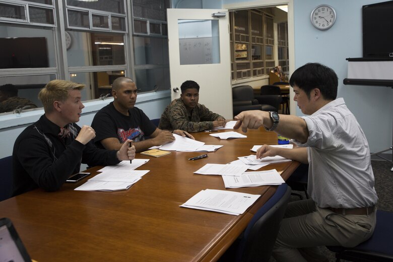Takaatsu Sueyoshi, right, instructs students on Japanese pronunciation during a Survival Japanese Language Class Nov. 29 on Marine Corps Air Station Futenma, Okinawa, Japan. The class taught students basic speech, reading and writing skills to enrich their experience while stationed on Okinawa. During the class, the instructor demonstrated the three basic writing styles called hiragana, katakana and kanji. After the demonstration, participants practiced reading, writing and speaking basic Japanese words and phrases. Sueyoshi is a library technician and the instructor of the Survival Japanese Language class. (U.S. Marine Corps photo by Cpl. Janessa K. Pon)
