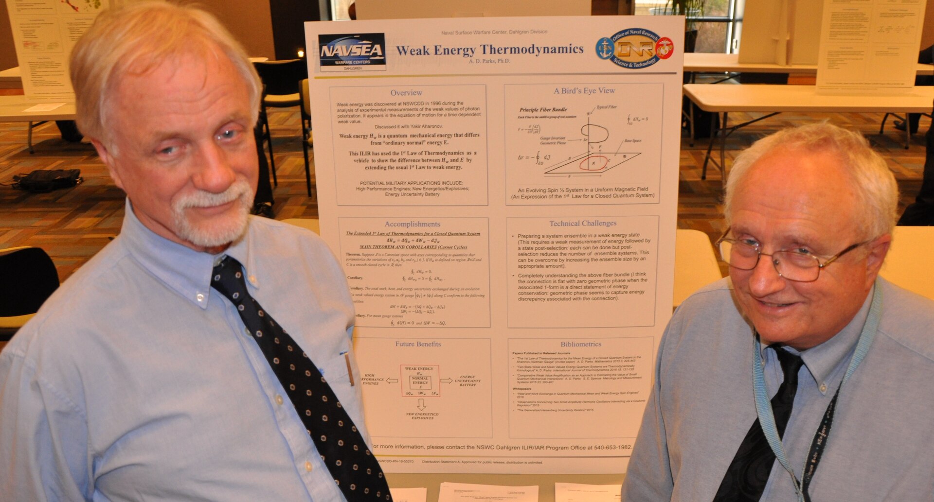 DAHLGREN, Va. – Navy scientists Dr. Dan Parks, left, and Dr. Jeffrey Solka are pictured with a poster explaining weak energy thermodynamics that Parks presented at a November 2016 poster session featuring Naval Surface Warfare Center Dahlgren Division (NSWCDD) In-house Laboratory Independent Research (ILIR) projects. Solka, the NSWCDD ILIR and Independent Applied Research Program Director, presented Parks with the command’s ILIR Excellence Award for his research over the course of ten years on weak energy and its properties at the event. Potential military applications of weak energy includes new energetics and explosives as well as significant impact to high performance engines and the storage of power for warfighters deployed to dangerous and remote regions.  