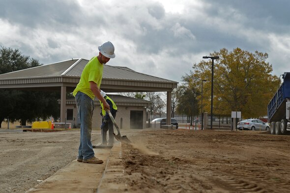 Hal Knopf, contracted construction worker, shovels dirt to keep the pavement clean at Shaw Air Force Base, S.C., Nov. 29, 2016. Contractors created multiple traffic lanes that will keep the flow of traffic moving while making it more difficult for unauthorized vehicles to gain access to the base. (U.S. Air Force photo by Airman 1st Class BrieAnna Stillman)