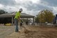 Hal Knopf, contracted construction worker, shovels dirt to keep the pavement clean at Shaw Air Force Base, S.C., Nov. 29, 2016. Contractors created multiple traffic lanes that will keep the flow of traffic moving while making it more difficult for unauthorized vehicles to gain access to the base. (U.S. Air Force photo by Airman 1st Class BrieAnna Stillman)