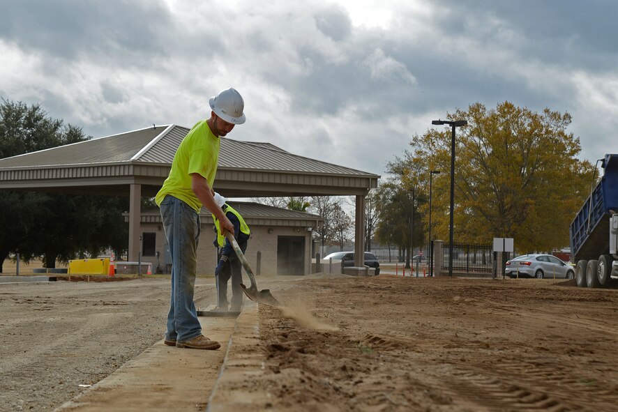 Hal Knopf, contracted construction worker, shovels dirt to keep the pavement clean at Shaw Air Force Base, S.C., Nov. 29, 2016. Contractors created multiple traffic lanes that will keep the flow of traffic moving while making it more difficult for unauthorized vehicles to gain access to the base. (U.S. Air Force photo by Airman 1st Class BrieAnna Stillman)