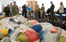 In the background, Dover First Sergeant Council members, additional duty first sergeants, wing leadership, donators and volunteers put together 211 Thanksgiving holiday food baskets for pre-selected Team Dover military families Nov. 18, 2016, at the Landings on Dover Air Force Base, Del. Each of the food baskets came with a frozen turkey. (U.S. Air Force photo by Roland Balik)