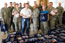 Master Sgt. Jamie Beard, 436th Security Forces Squadron first sergeant, accepts a check on behalf of the Dover First Sergeant Council from Tyler Kuhn, Dover Federal Credit Union community relations, Nov. 18, 2016, at the Landings on Dover Air Force Base, Del. In addition to the monetary donation, DFCU provided 211 thermal grocery bags for the Thanksgiving holiday food baskets. (U.S. Air Force photo by Roland Balik)