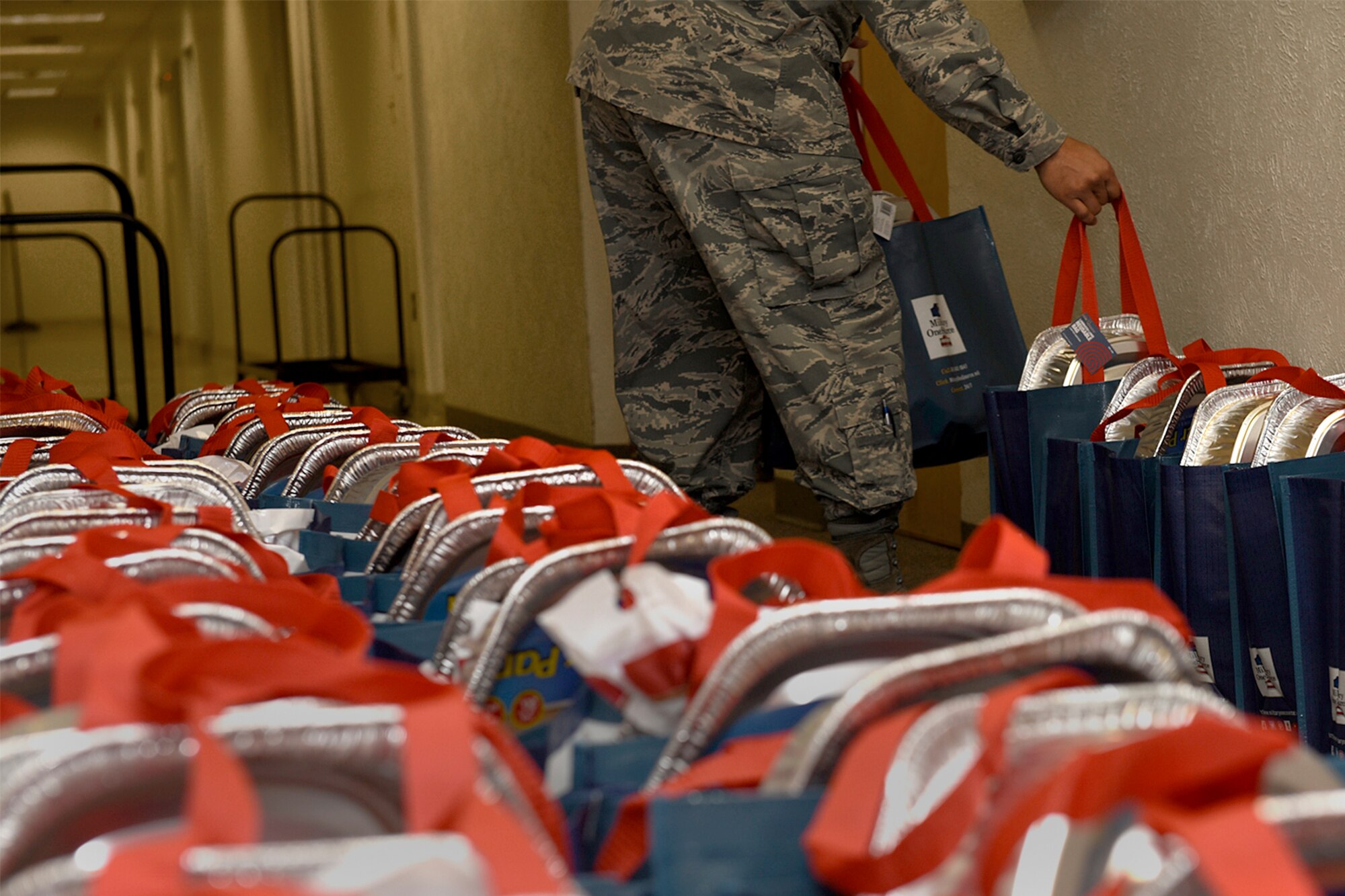 PETERSON AIR FORCE BASE, Colo. – A Peterson first sergeant lines up bags of Thanksgiving food items at the base chapel on Peterson Air Force Base, Colo., Nov. 21, 2016. The first sergeants put together Thanksgiving baskets to distribute to Airmen who needed assistance during the holiday. (U.S. Air Force photo by Senior Airman Rose Gudex)