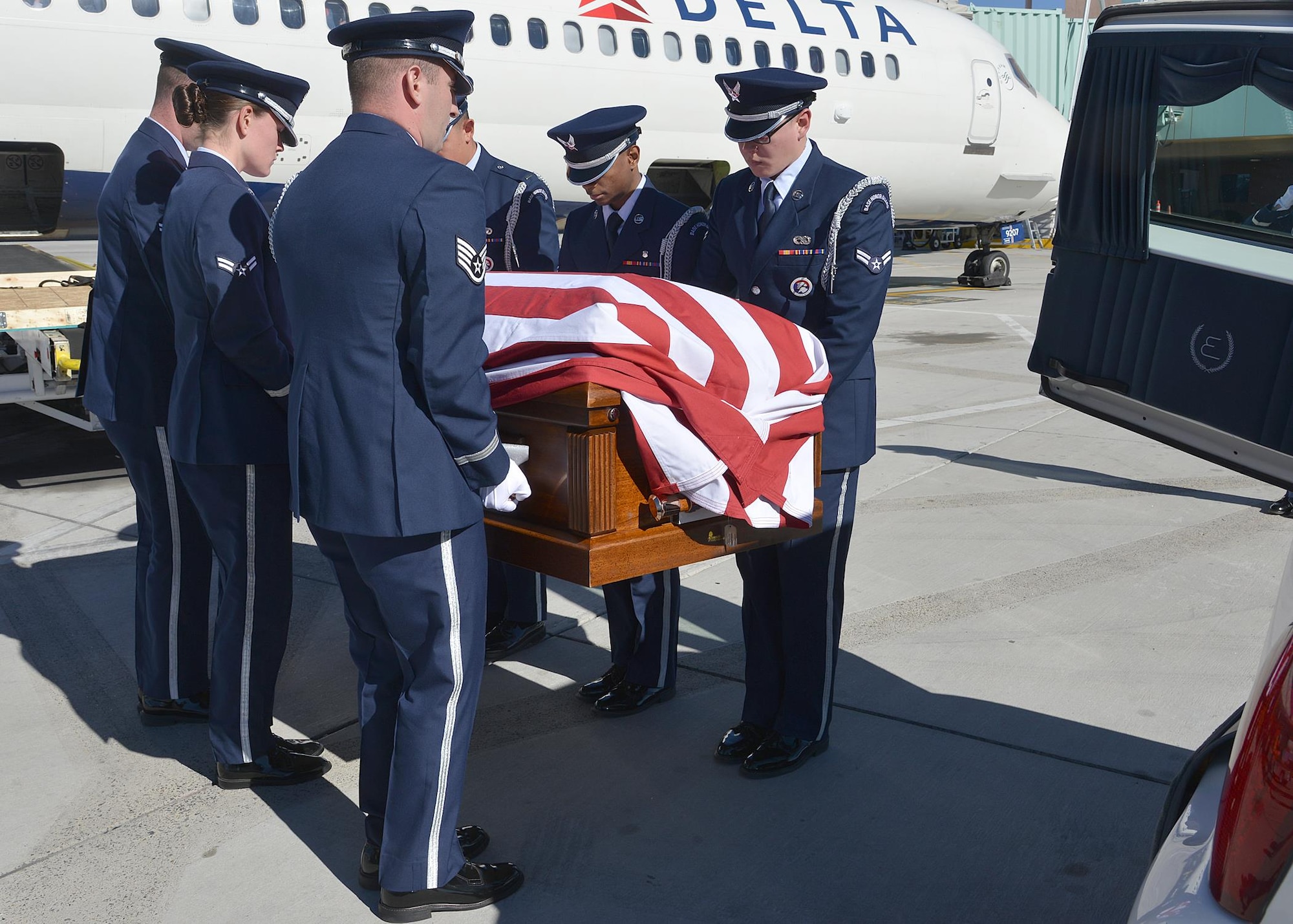 Kirtland Air Force Base Honor Guard members act as pallbearers for Tech. Sgt. Nicholas Heck on Nov. 18 as his remains arrive at the Albuquerque International Sunport en route to Cannon Air Force Base for the funeral. This dignified arrival, the primary mission of honor guards, was the first
KAFB Honor Guard has performed in many years. Six Honor Guard members act as pallbearers and a seventh renders a salute. Heck was stationed at Cannon before transferring to Yakota Air Base, Japan, where he died.