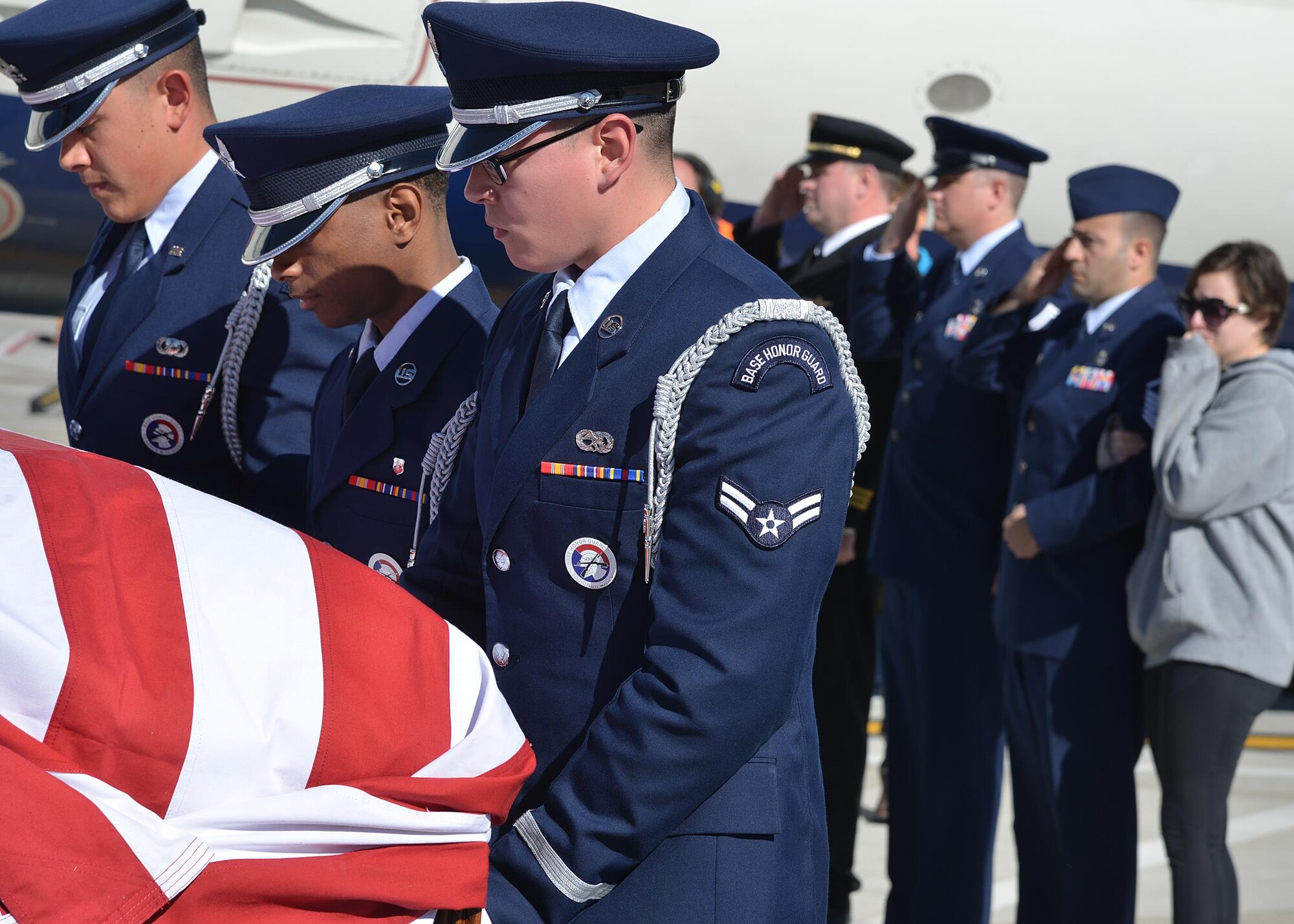 Kirtland Air Force Base Honor Guard members act as pallbearers for Tech. Sgt. Nicholas Heck on Nov. 18 as his remains arrive at the Albuquerque International Sunport en route to Cannon Air Force Base for the funeral. This dignified arrival, the primary mission of honor guards, was the first
KAFB Honor Guard has performed in many years. Six Honor Guard members act as pallbearers and a seventh renders a salute. Heck was stationed at Cannon before transferring to Yakota Air Base, Japan, where he died.