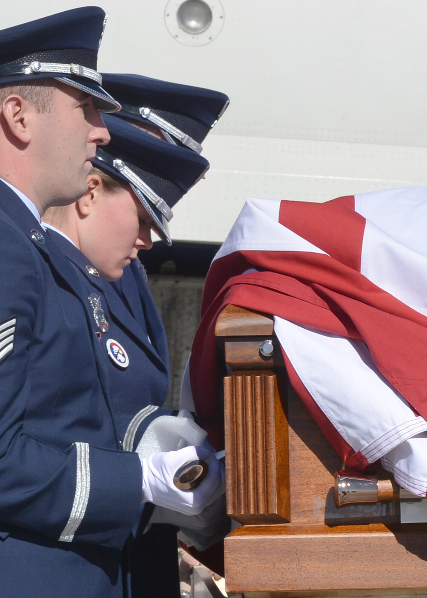 Kirtland Air Force Base Honor Guard members act as pallbearers for Tech. Sgt. Nicholas Heck on Nov. 18 as his remains arrive at the Albuquerque International Sunport en route to Cannon Air Force Base for the funeral. This dignified arrival, the primary mission of honor guards, was the first
KAFB Honor Guard has performed in many years. Six Honor Guard members act as pallbearers and a seventh renders a salute. Heck was stationed at Cannon before transferring to Yakota Air Base, Japan, where he died.