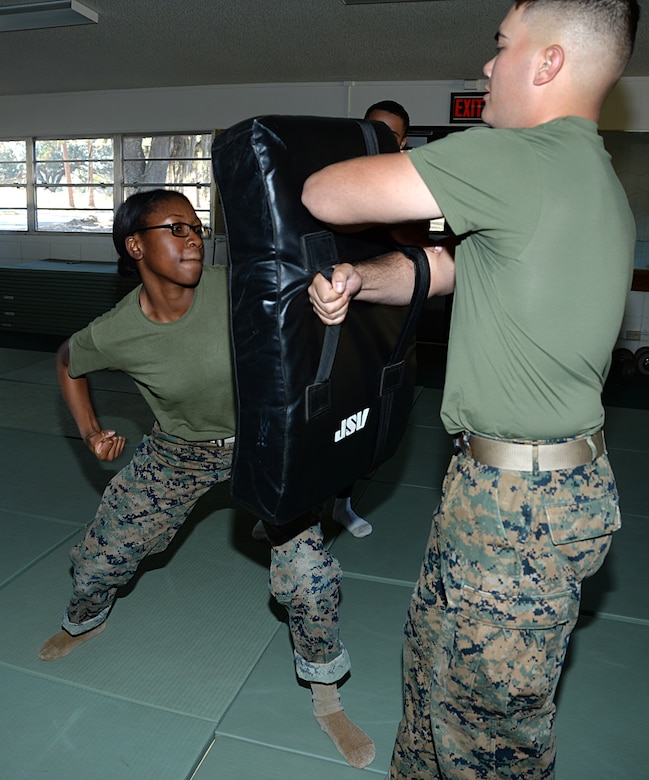 Pfc. Mykerria Johnson, (left), Marine Corps Martial Arts Program student, Marine Corps Logistics Base Albany, conducts an uppercut on Lance Cpl. Darin Brooks, MCMAP student, training pad, Nov. 21. 
