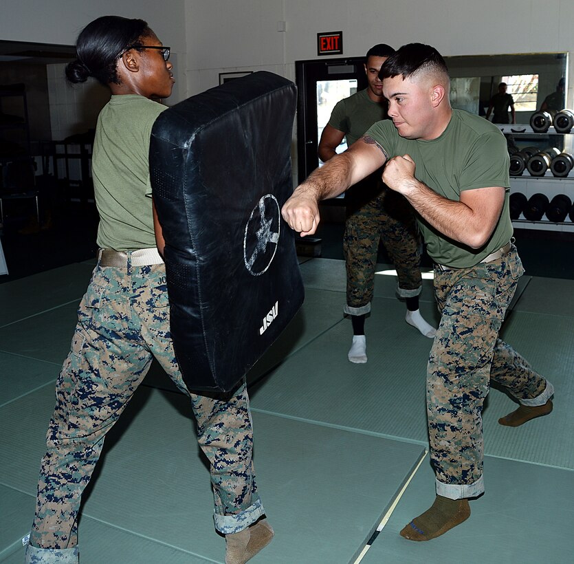 Lance Cpl. Darin Brooks, (right), Marine Corps Martial Arts Program student, Marine Corps Logistics Base Albany, performs a rear hand punch on Pfc. Mykerria Johnson, MCMAP student, training pad, Nov. 21. 