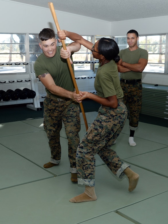 Pfc. Mykerria Johnson, (center), Marine Corps Martial Arts Program student, Marine Corps Logistics Base Albany, executes a counter to the overhand grab technique as Lance Cpl. Darin Brooks, MCMAP student, tries to grab her simulated rifle while Sgt. Josue Balbuena, MCMAP instructor, observes, Nov. 21. 