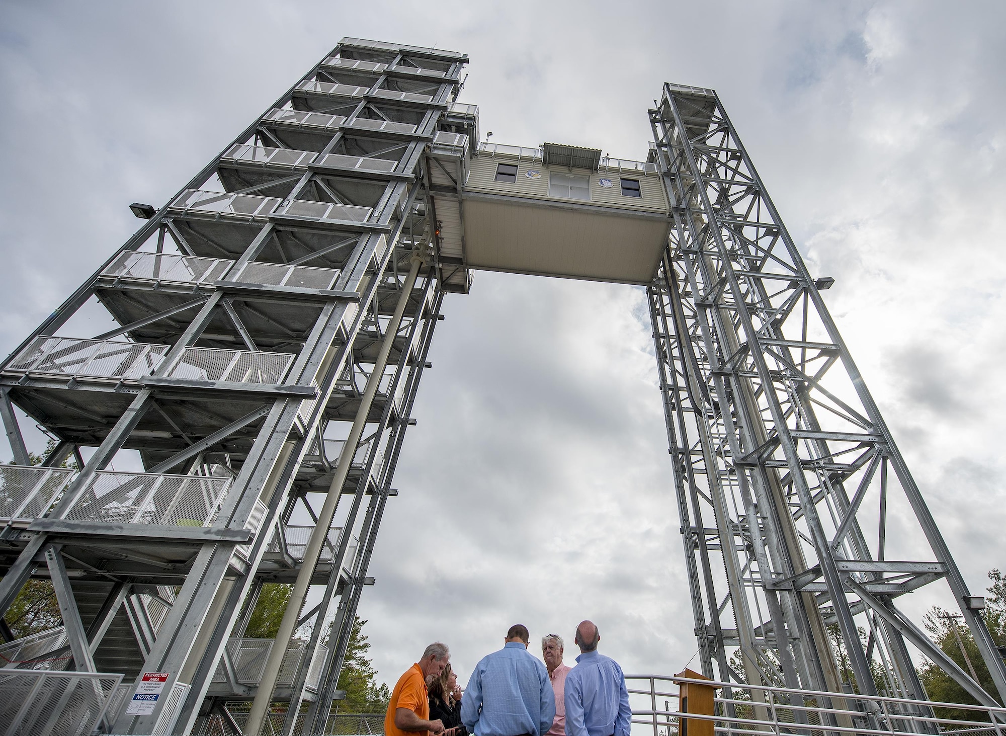 The Air Force Research Lab Munitions Directorate’s variable height tower nears its top level as people watch Nov. 29 at Eglin Air Force Base, Fla.  A ribbon cutting ceremony was held for the new structure located on Eglin’s range.  The new capability enables researchers at the C-86 range to take improved sensor data because it reduces signal interferences caused by the warmer air and objects near the ground. (U.S. Air Force photo/Samuel King Jr.)