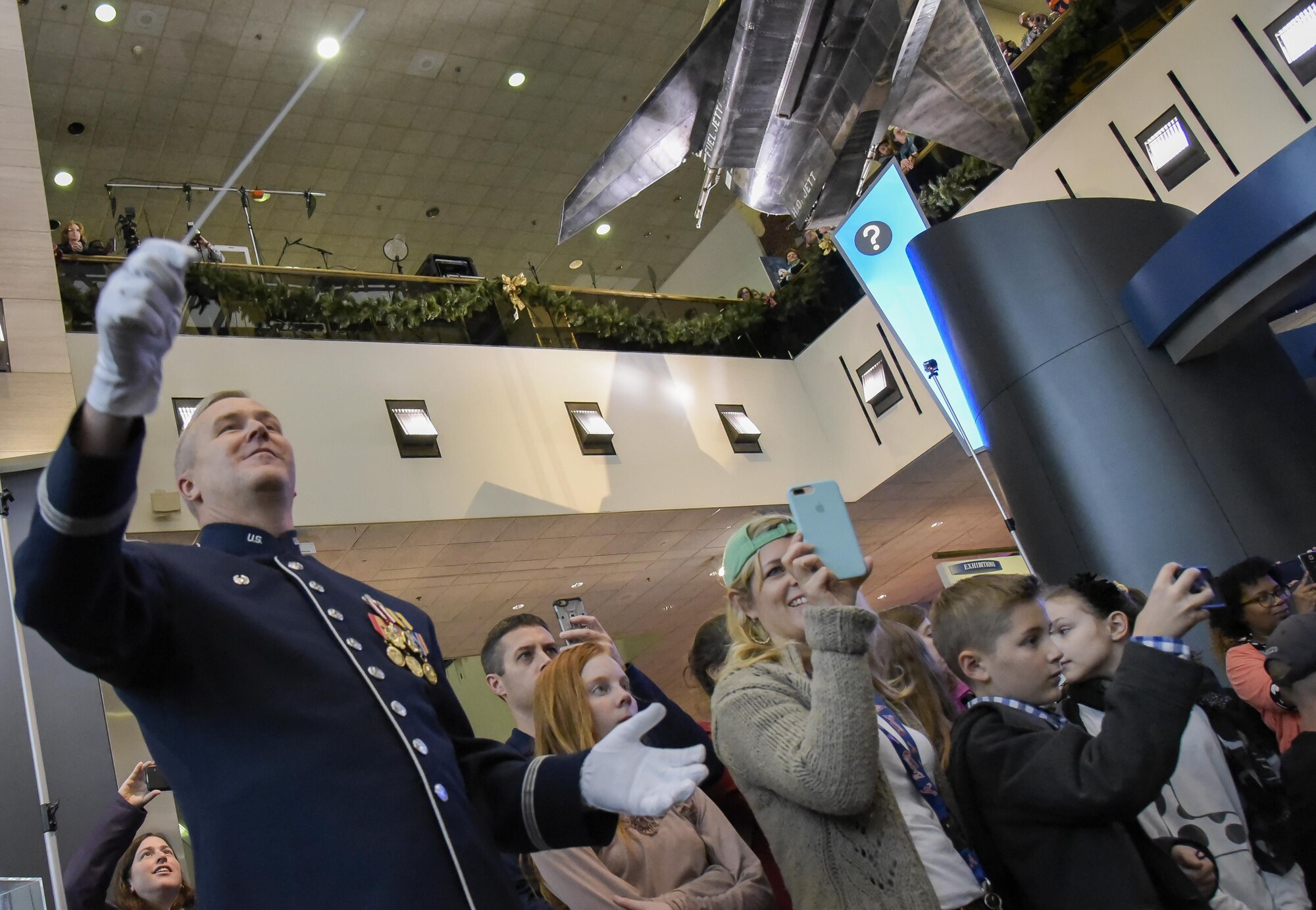 U.S. Air Force Band Commander Col. Larry H. Lang conducts the band's annual holiday flash mob performance at the Smithsonian National Air and Space Museum in Washington, D.C., Nov. 29, 2016. (U.S. Air Force photo by Jim Varhegyi)(released)