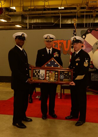 Capt. Charles Phillip recieves his shadow box at a Change of Command and retirement ceremony held at Naval Munitions Command Atlantic Unit Charleston (NMCLANTUC) here. NMCLANTUC defines itself as the premier munitions facility on the east coast   (U.S. Navy Photo by Mass Communication Specialist 1st Class Sean M. Stafford/Released)