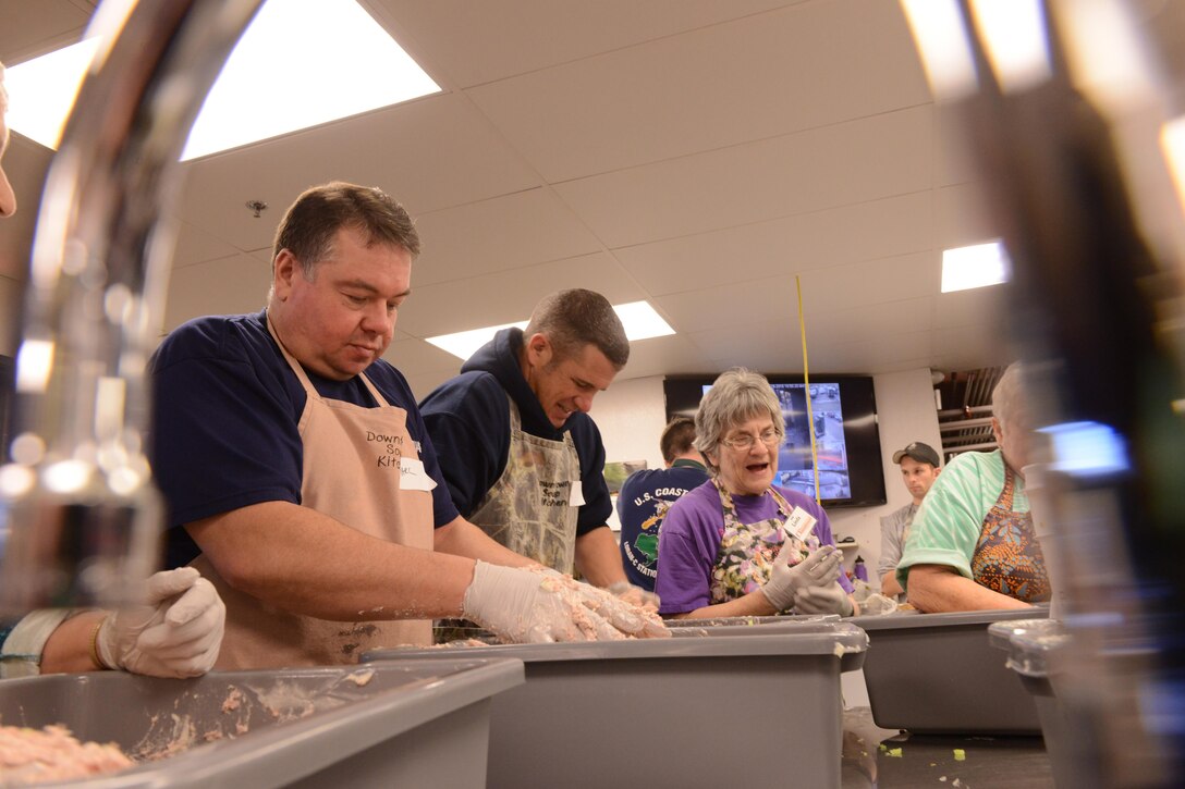 Coast Guard Chief Warrant Officers Mark Riedlinger, left, and Dustin Overturf, center, prepare food and care packages for the homeless at the Downtown Soup Kitchen Hope Center in Anchorage, Alaska, Nov. 29, 2016. Coast Guard photo by Petty Officer 1st Class Bill Colclough.