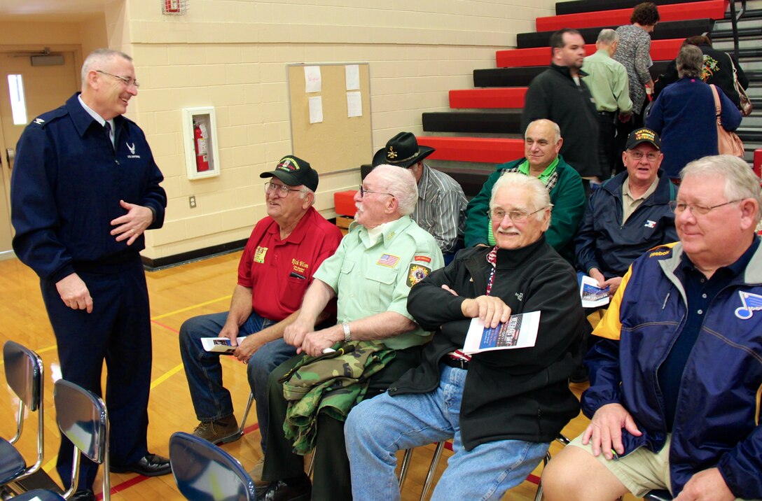 The 932nd Airlift Wing's commander thanks other former service members while telling the veteran's story to the public.  Before taking the podium to recognize Veterans Day while speaking at Highland Junior High School recently, the commander of the 932nd Airlift Wing, Col. Jonathan Philebaum (at left), made a point to reach out to some of the veterans he saw there from past United States military history, to thank them for serving America and for remembering others on this day. Col. Philebaum spoke to an estimated crowd of over 700 people on November 10, 2016 in Highland, Ill. (U.S. Air Force photo by Lt. Col. Stan Paregien)