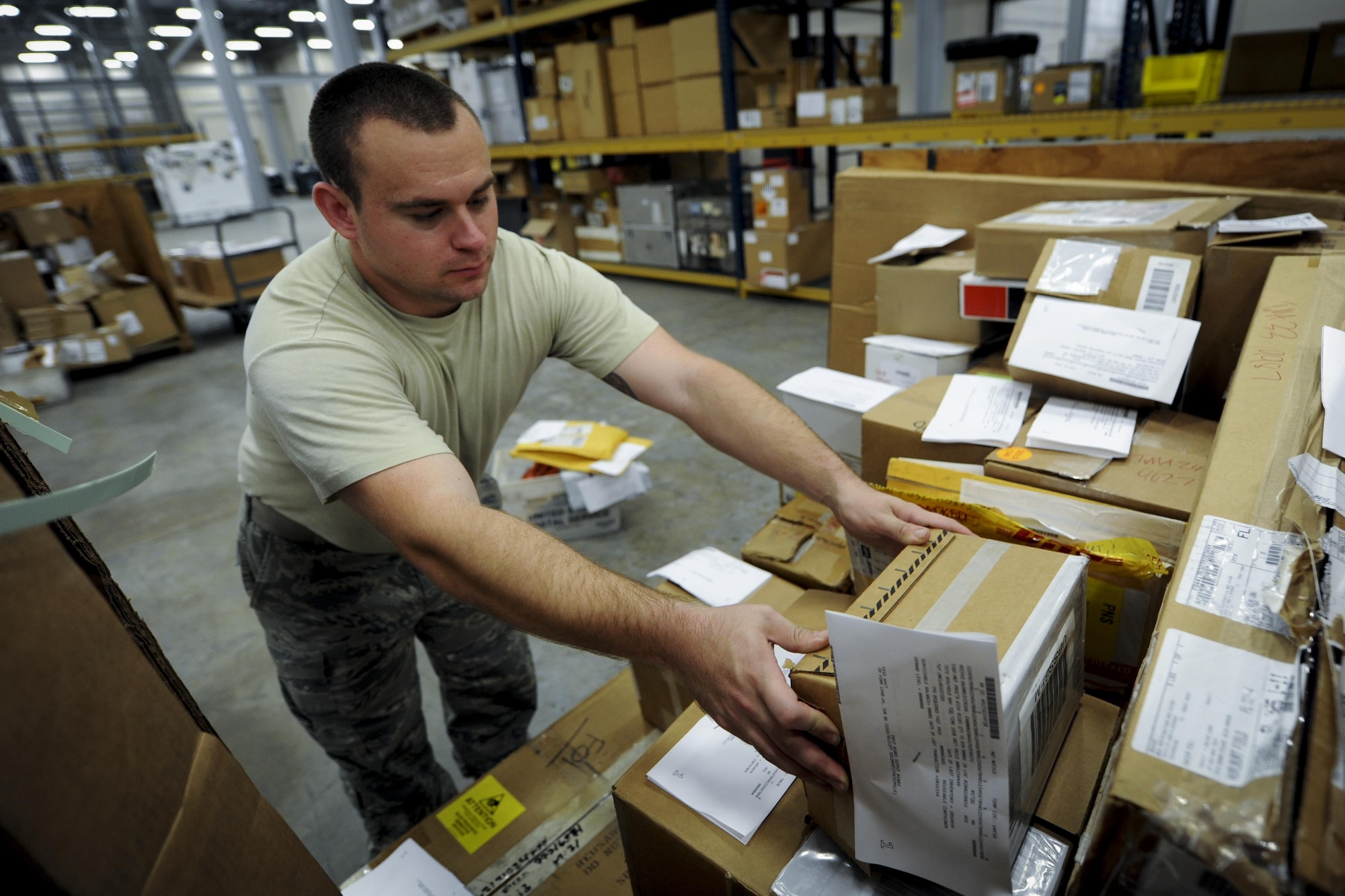 Senior Airman Sean Mackinnon, a traffic management journeyman with the 1st Special Operations Logistics Readiness Squadron, places a package in a storage bin at Hurlburt Field, Fla., Nov. 29, 2016. The squadron handles as many as 1,500 items daily to be distributed to different squadrons on base, other Air Force installations and deployed locations. (U.S. Air Force photo by Airman Dennis Spain)