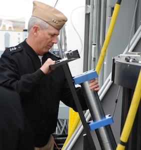 Vice Adm. Thomas Moore, commander of the Naval Sea Systems Command (NAVSEA), loads an electromagnetic railgun projectile into the electromagnetic railgun during his visit to the Naval Surface Warfare Center Dahlgren Division, Nov. 30. Electromagnetic railgun technology uses an electromagnetic force to rapidly accelerate and launch a projectile between two conductive rails. The guided projectile is launched at such high velocities that it can achieve greater ranges than conventional guns. It harnesses enough kinetic energy that it doesn't require any kind of high explosive payload when it reaches its target.