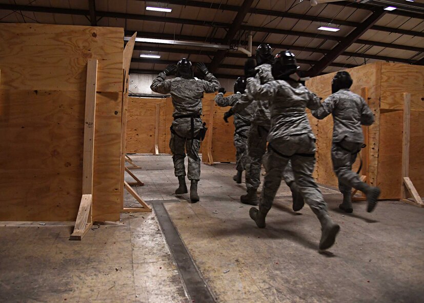 Members of the 319th Security Forces Squadron run out of the “shoot house” Nov. 29, 2016, on Grand Forks Air Force Base, N.D. The Airmen were acting as hostages in a security forces training scenario. (U.S. Air Force photo by Senior Airman Ryan Sparks)