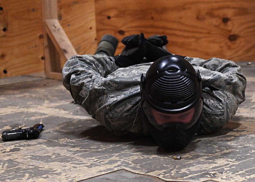 Senior Airman Robert Zerby, 319th Security Forces Squadron unit scheduler, simulates being subdued in handcuffs Nov. 29, 2016, on Grand Forks Air Force Base, N.D. Members of the 319th SFS practiced clearing buildings and were met by simulated attackers and hostages. (U.S. Air Force photo by Senior Airman Ryan Sparks)