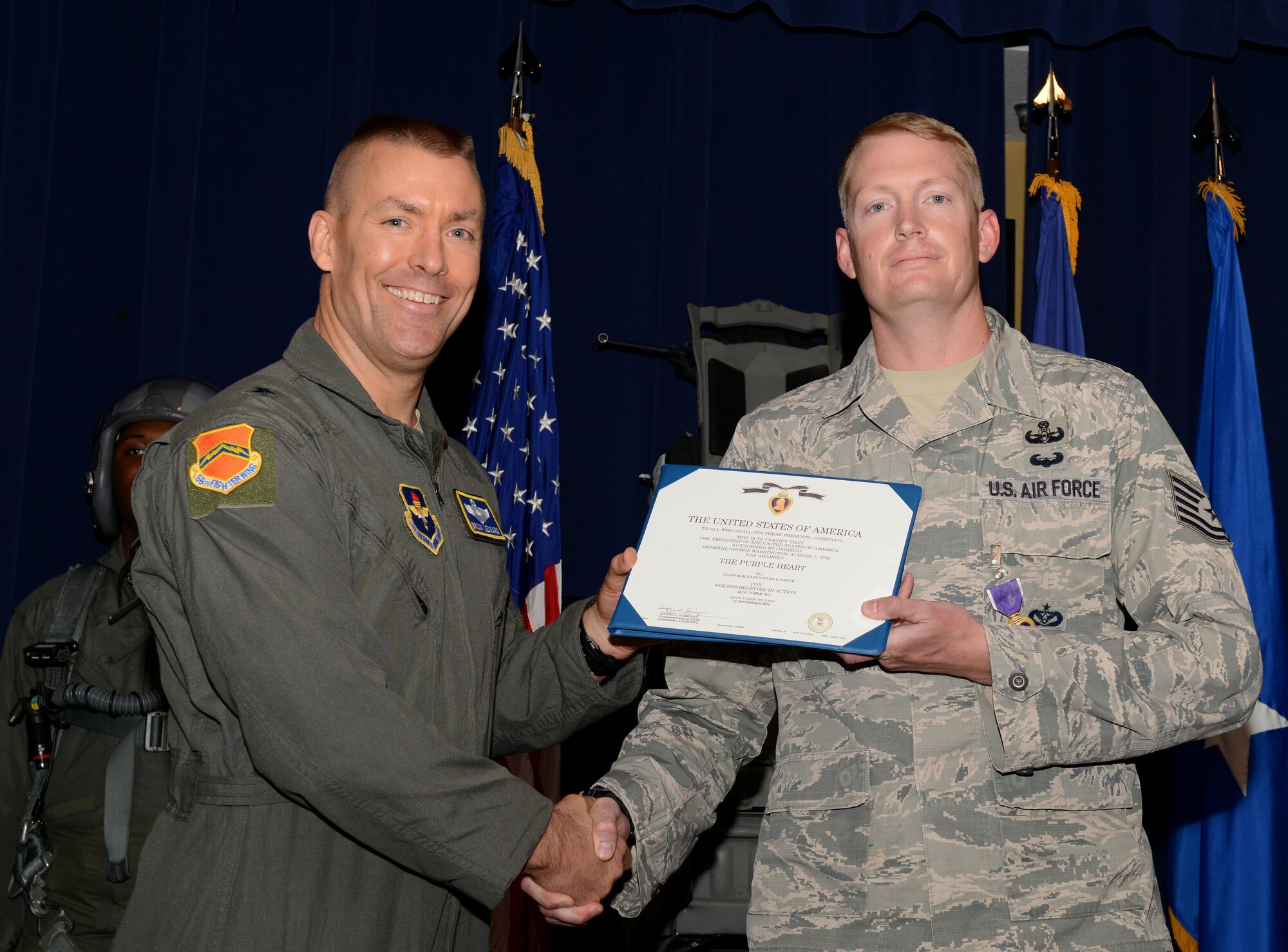 Tech. Sgt. Steven Dauck, 56th Civil Engineer Squadron explosive ordinance disposal team leader, receives the Purple Heart Medal from Brig. Gen. Brooke Leonard, 56th Fighter Wing commander, Nov. 30, 2016, at Luke Air Force Base, Ariz. Dauck received his Purple Heart for his actions during a route clearance patrol where he was hit by an improvised explosive device in Afghanistan, Oct. 28, 2011. (U.S. Air Force photo by Airman 1st Class Alexander Cook)  