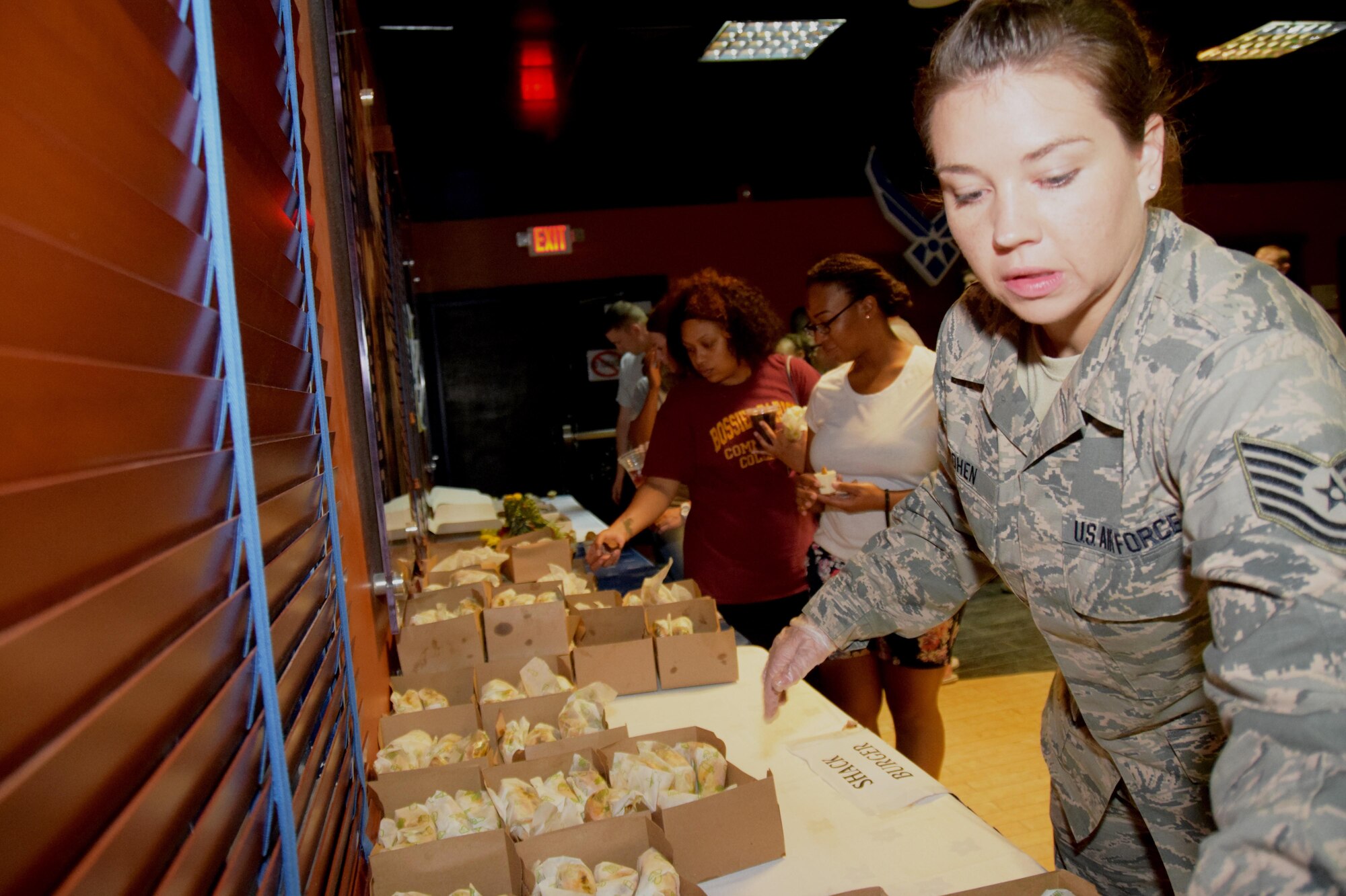 Tech. Sgt. Kirsten Cohen, 379th Expeditionary Force Support Squadron quality assurance technician, arranges sandwiches and desserts at a table inside the Fox Sports Lounge Sept. 23, 2016, at Al Udeid Air Base, Qatar. The free food was served at the Air Force Birthday Ball after-party. (U. S. Air Force photo/Tech. Sgt. Carlos J. Trevino/Released)