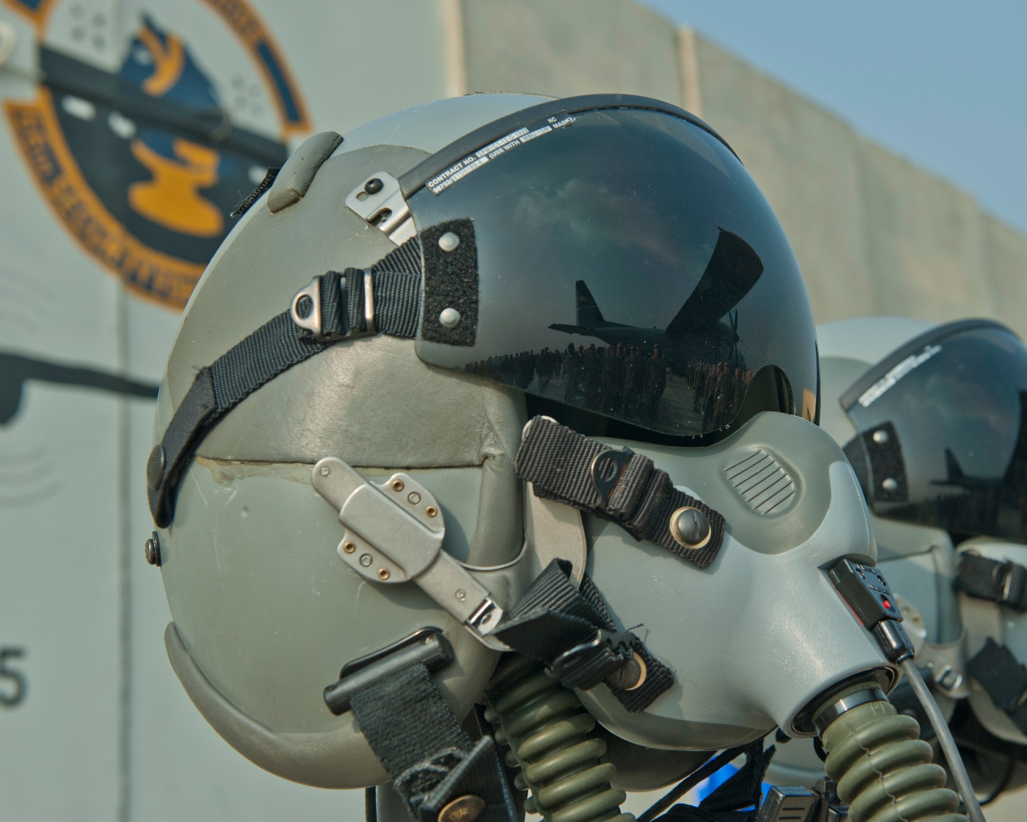 A reflection of Airmen is displayed on the visor of a pilots helmet, Bagram Airfield, Afghanistan, Oct. 2, 2016. A remembrance ceremony was held to honor those lost when TORQE 62 crash on Oct. 2, 2015. The helmets were part of a display to remember and honor the fallen. (U.S. Air Force photo by Capt. Korey Fratini)