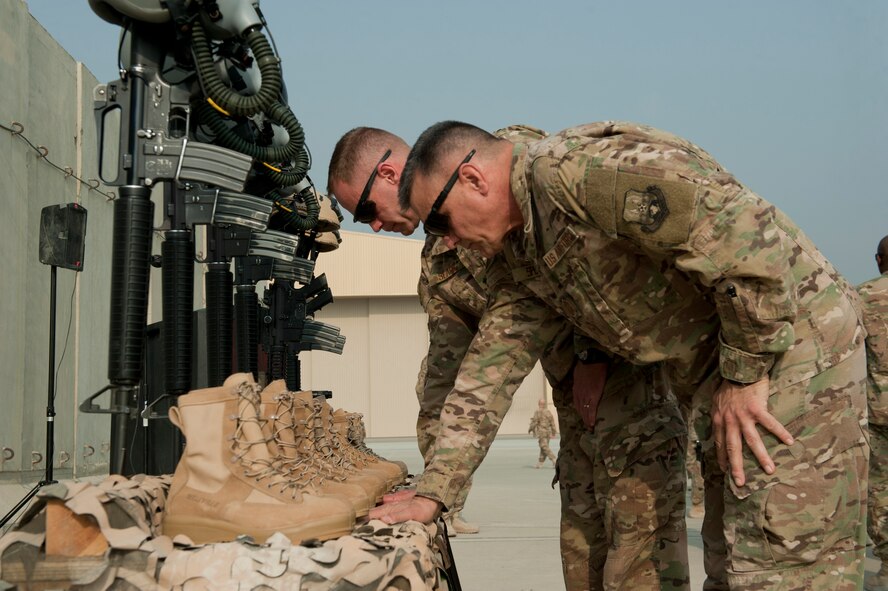 U.S. Air Force Brigadier General James Sears, 455th Air Expeditionary Wing, commander and  U.S. Air Force Chief Master Sgt. Peter Speen, 455th AEW, command chief, pause to honor six Airmen during the TORQE 62 remembrance ceremony, Bagram Airfield, Afghanistan, Oct. 2, 2016. Airmen came together to honor those lost when TORQE 62 crashed one year ago, (U.S. Air Force photo by Capt. Korey Fratini)