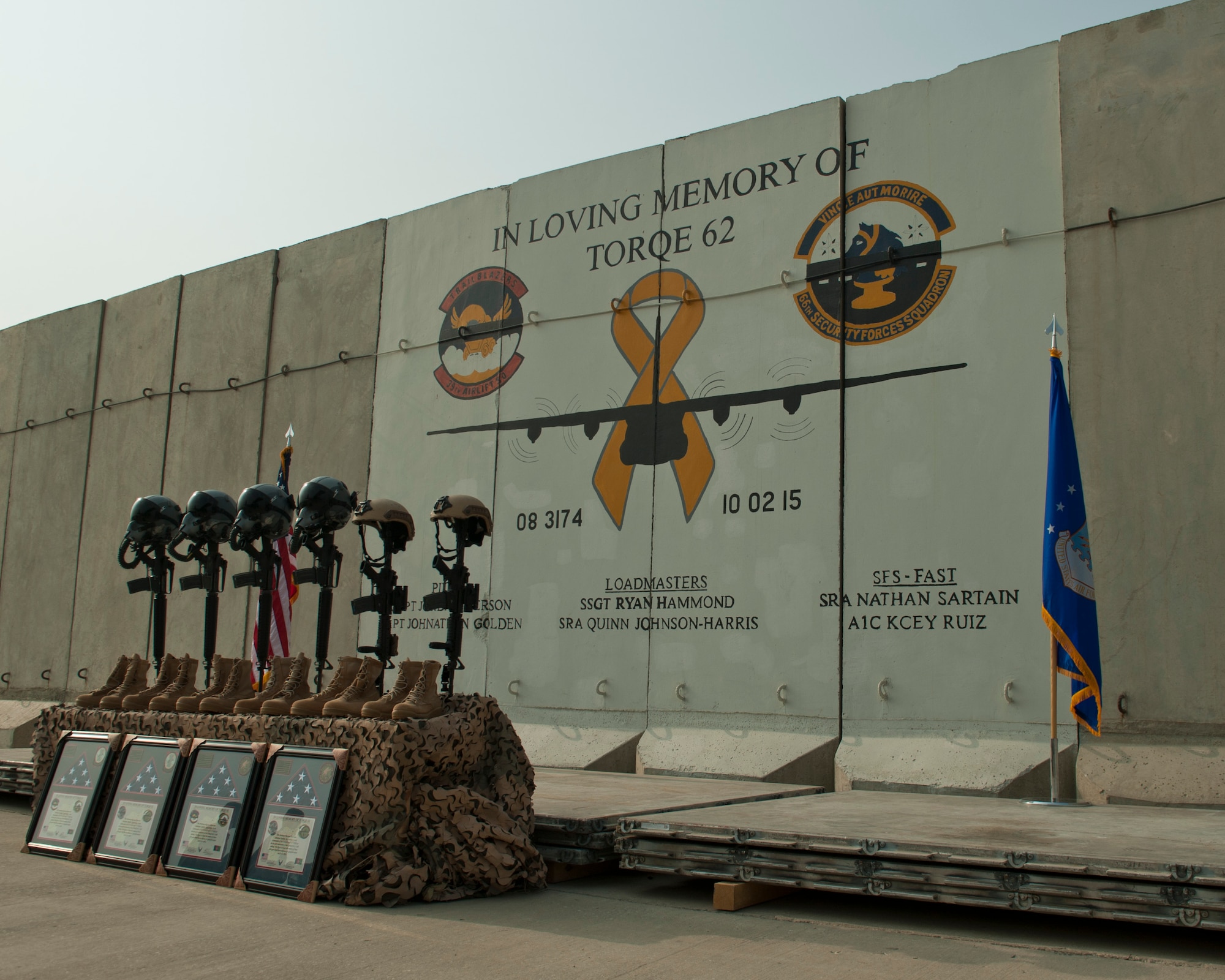 Battlefield crosses representing the six Airmen lost during a C-130J crash, are placed in front of a mural in memory of TORQE 62, Bagram Airfield, Afghanistan, Oct. 2, 2016. A ceremony was held to remember and honor the live lost when TORQE 62 crash during takeoff at Jalalabad Airfield, Afghanistan, Oct. 2, 2015. (U.S. Air Force photo by Capt. Korey Fratini)