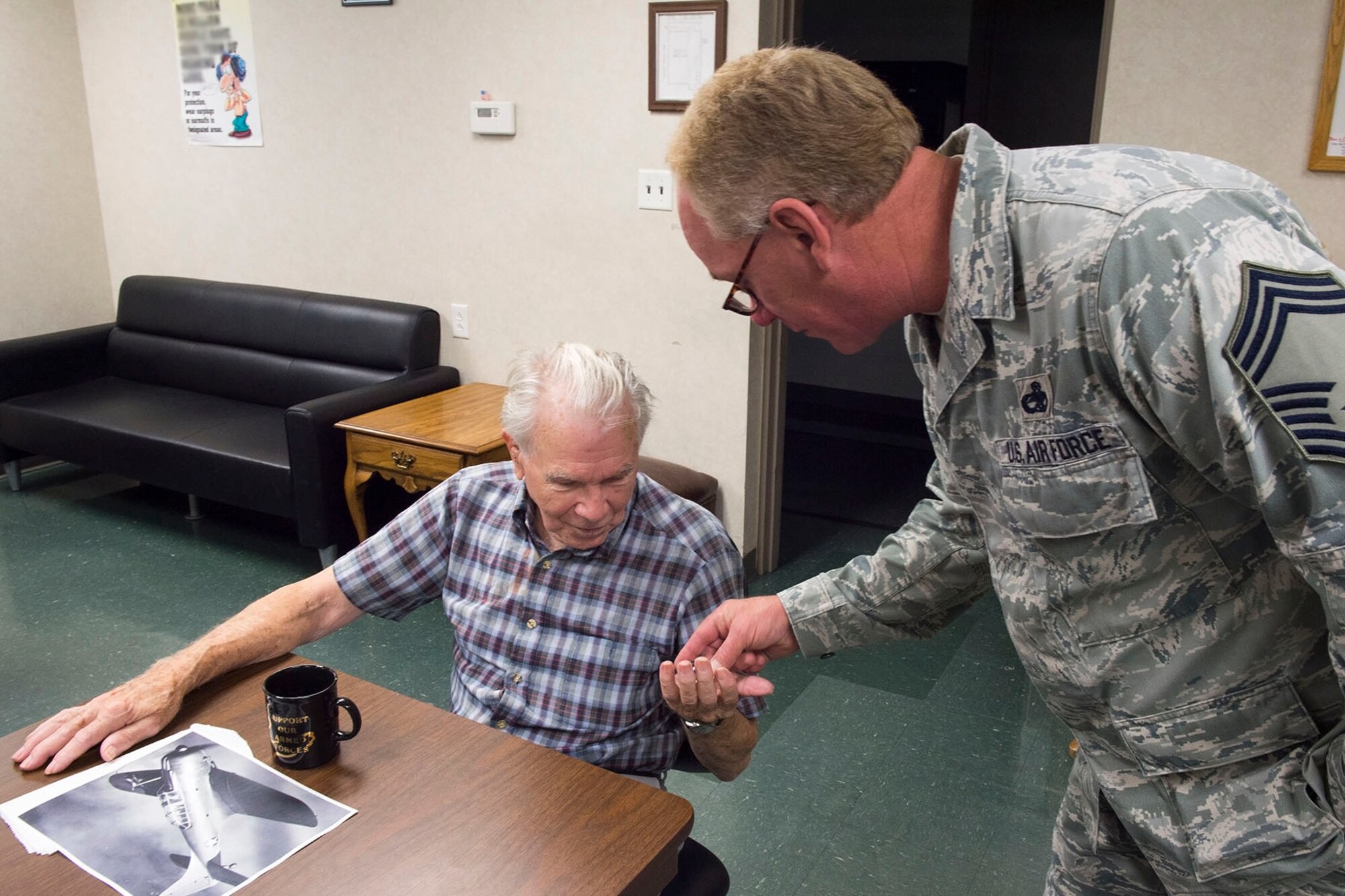 Chief Master Sgt. Patrick Devine, 434th Aircraft Maintenance Squadron aircraft manager, coins (Ret.) Lt. Col. Richard Hyman during a recent visit. Richard, a WWII and Korean War veteran, served at what was then known, Bunker Hill Air Force Base, Ind., until he retired in 1965. (U.S. Air Force photo/Staff Sgt. Jami K. Lancette)
